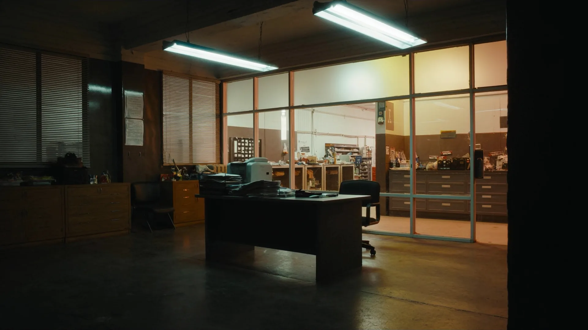 Empty estimator office. Plans and a desk. No product chrome.