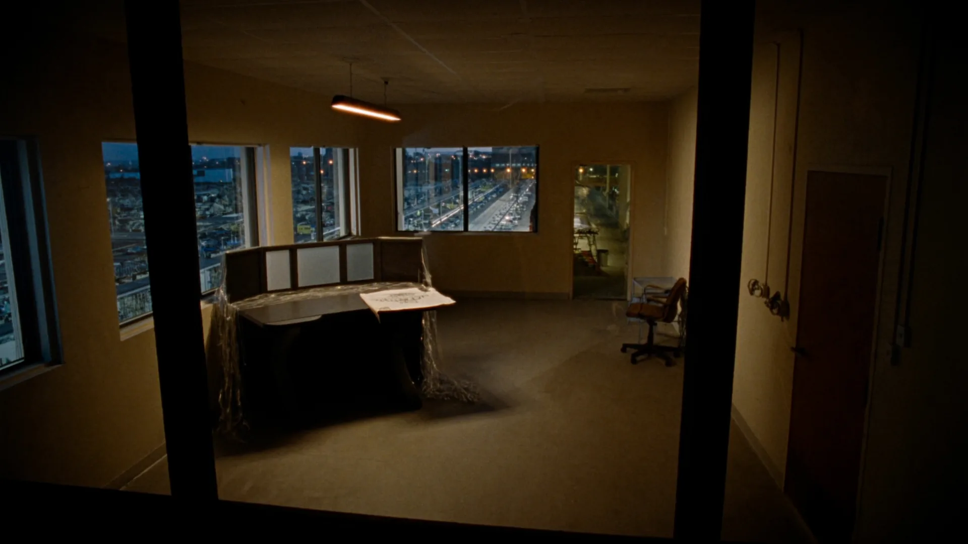 Empty estimator office. Plans and a desk. No product chrome.